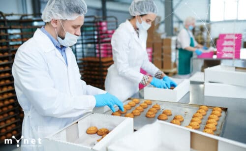 la sicurezza aziendale ai tempi del Coronavirus: persone che lavorano distanziate e con la mascherina