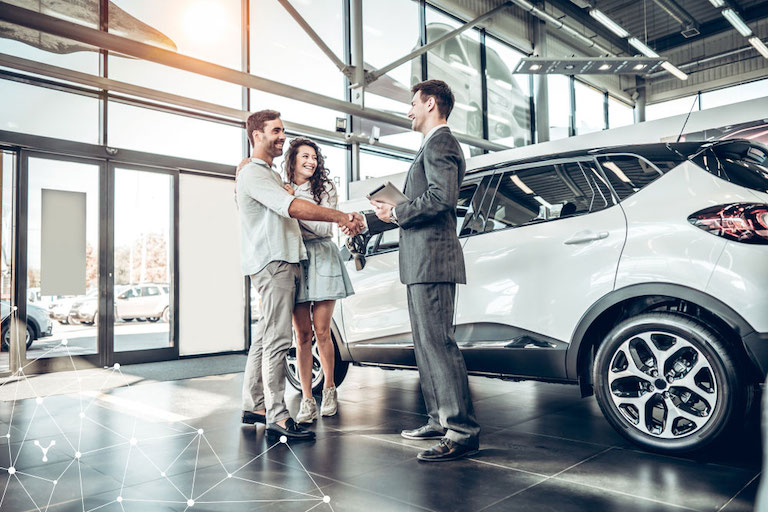 immagine rappresentativa del settore automotive con venditore e clienti del salone auto