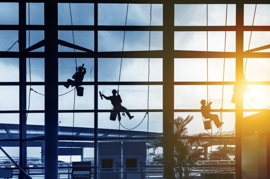 software servizi facility management: lavoratori che puliscono i vetri di un palazzo