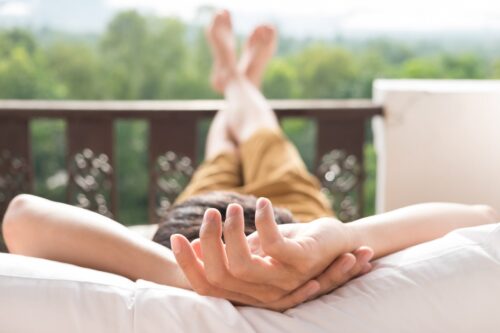 depressione post vacanze: persona distesa al sole con le braccia dietro alla testa in posa rilassata