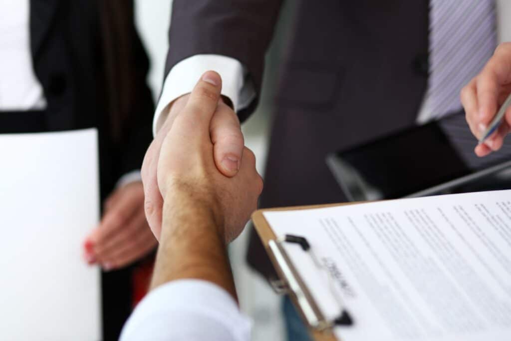 contratti di lavoro: professionisti che si stringono la mano dopo il colloquio