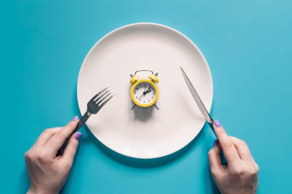 pausa pranzo obbligatoria: piatto con sveglia su sfondo azzurro