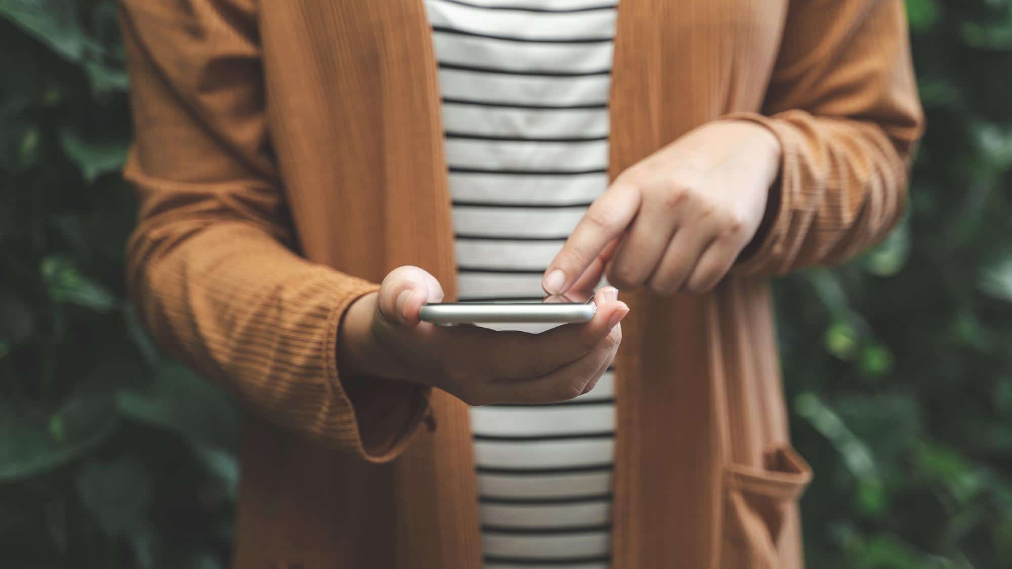 primo piano di persona che utilizza il touchscreen del proprio cellulare