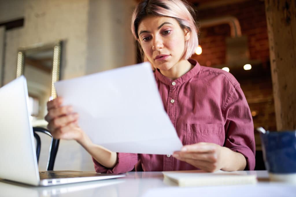 lavoratrice davanti al pc che consulta un foglio