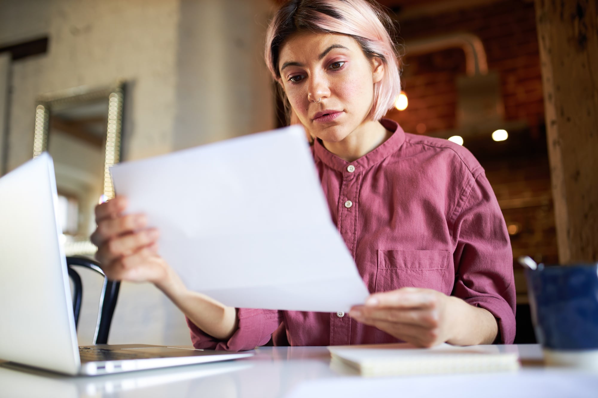 lavoratrice davanti al pc che consulta un foglio