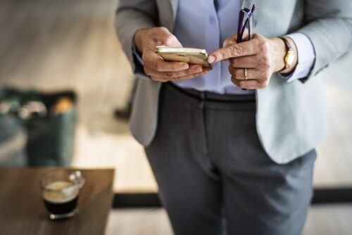 professionista in abito elegante che utilizza la chat aziendale interna da smartphone
