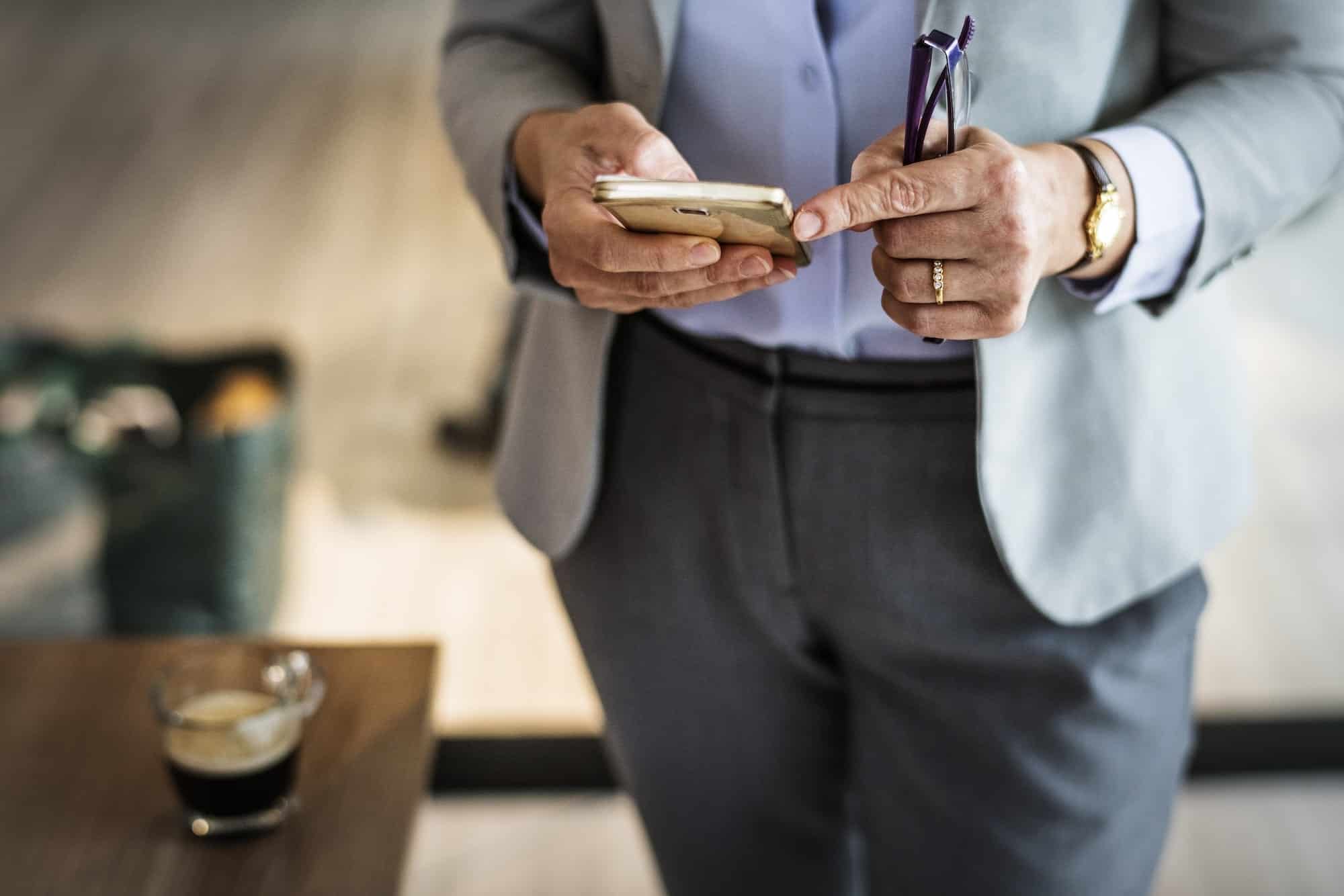 professionista in abito elegante che utilizza la chat aziendale interna da smartphone