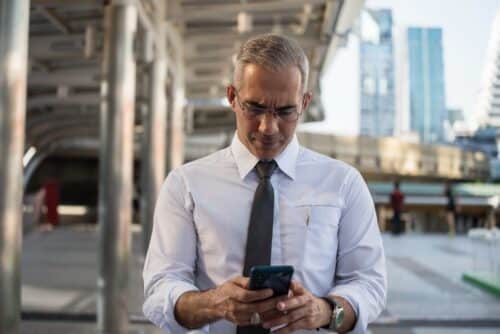 professionista in camicia che effettua la timbratura del cartellino da smartphone