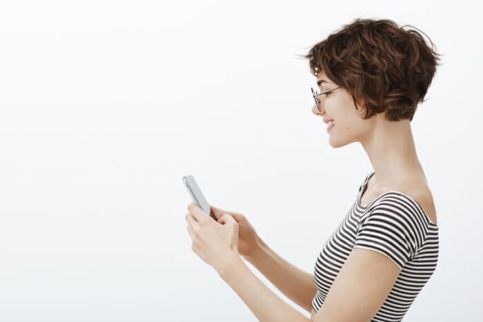 ragazza di profilo su sfondo bianco che utilizza App MyNet per la gestione ferie