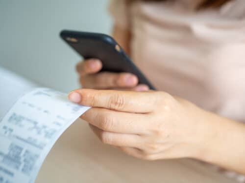 donna che fotografa il giustificativo di spesa tramite app aziendale per rimborso scontrini